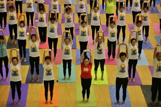 People practise yoga on International Yoga Day last year in Hanoi (Source: baomoi.com