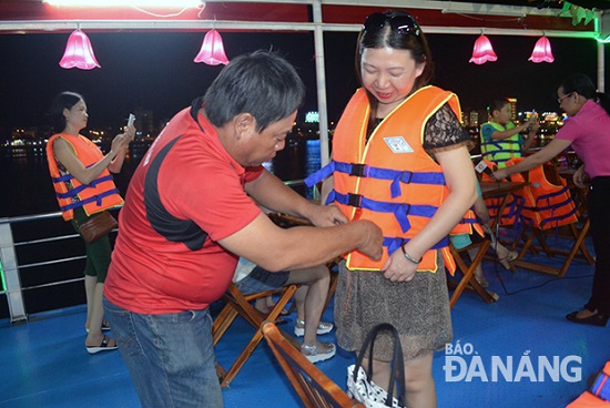 A passenger being helped into a life jacket