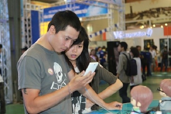 Customers use smartphones at an exhibition in Ha Noi. (Photo:VNA)