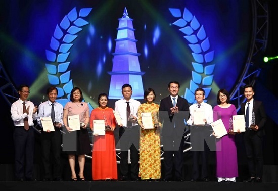 President Tran Dai Quang (fourth, right) and Chairman of the Party Central Committee's Information and Education Commission Vo Van Thuong (first, left) and the A prize winners (Photo: VNA)