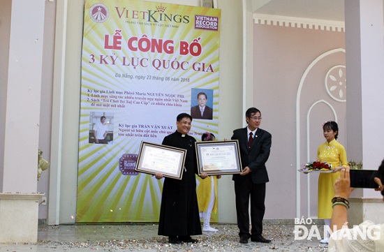 Priest Nguyen Ngoc Phi (first left) receiving his record certificates