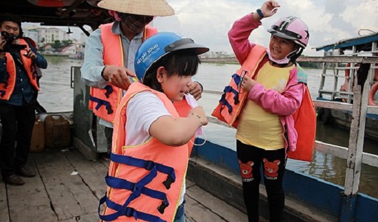 Young passengers put on life jackets at the Phu Cuong ferry wharf in Cu Chi District, Ho Chi Minh City. Tuoi Tre