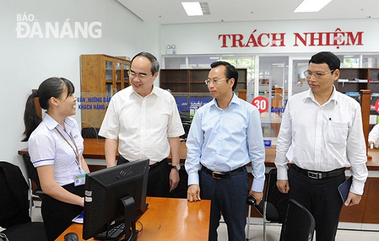 President Nhan (second left) and city leaders speaking to a local government employee (first left) at the city’s Administrative Centre