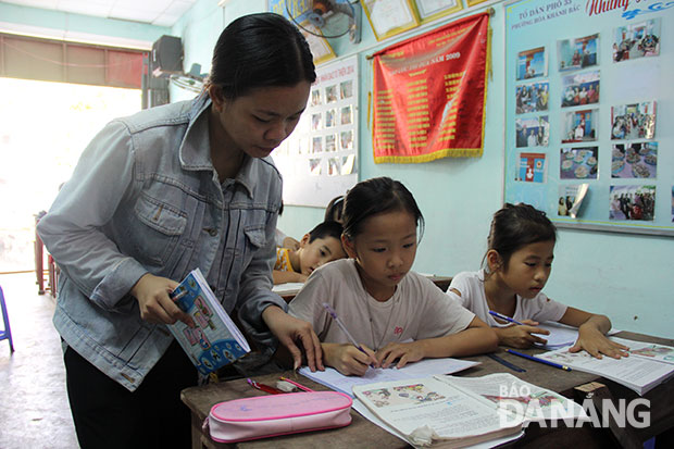 Cô giáo Trần Thị Tuyết Trinh tận tình hướng dẫn các em tập đọc, tập viết. Ảnh: Quốc Khải