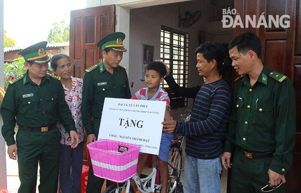 Bộ đội Biên phòng thành phố Đà Nẵng trao quà của chương trình “Nâng bước em tới trường” cho học sinh nghèo vượt khó tại phường Hòa Hiệp Bắc, quận Liên Chiểu.  			     Ảnh: BÁ VĨNH