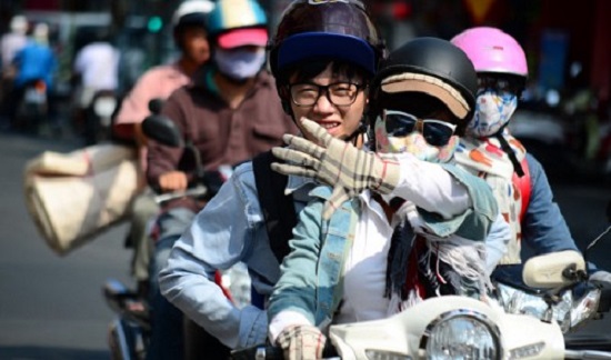 A female driver armed with sunglasses, mask, hat, scarf and gloves to protect her skin. Tuoi Tre