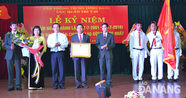 Thừa ủy nhiệm Chủ tịch nước, Bí thư Trung ương Đảng, Chánh văn phòng Trung ương Đảng Nguyễn Văn Nên trao Huân chương Lao động hạng nhất cho tập thể Cục Quản trị T26.  		           Ảnh: ĐOÀN LƯƠNG 