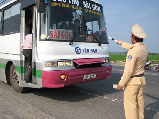 a police officer stopping a passenger coach at the roadside