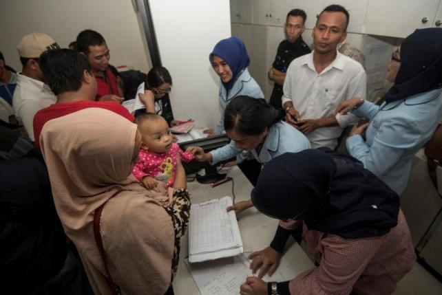 Hospital workers (R) collect information from parents who believe their children may have received fake vaccines at a hospital in East Jakarta, Indonesia. (Source: reuters.com)