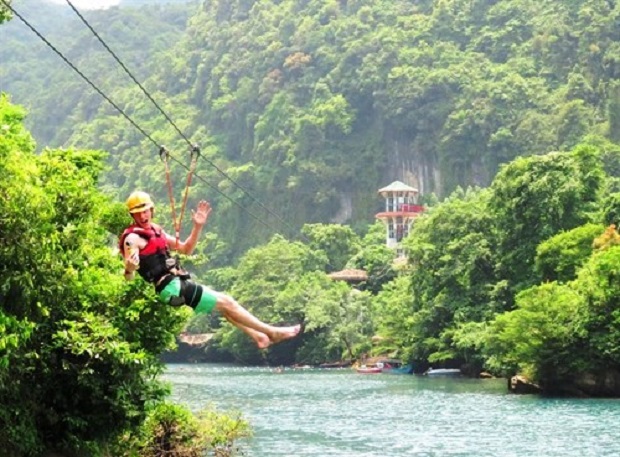 A tourist rides a zipline across Chay River to Toi Cave in Quang Binh province (Source:VNA)