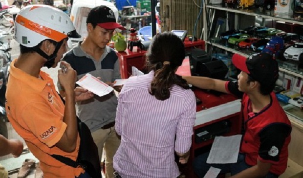 Buyers are shown how the lottery works at a Mega 6/45 lottery point of sale in District 5, Ho Chi Minh City. Tuoi Tre