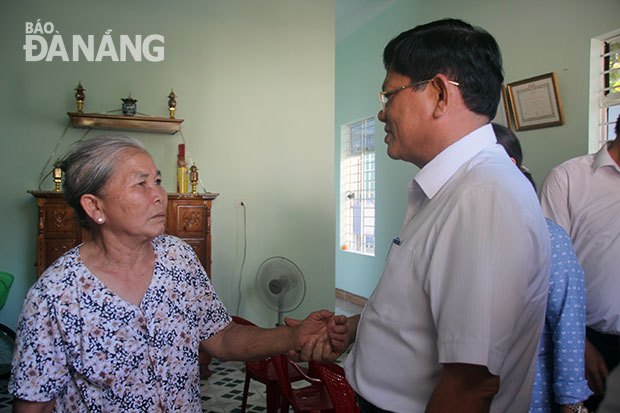 A local social policy beneficiary in her newly-repaired house (left)