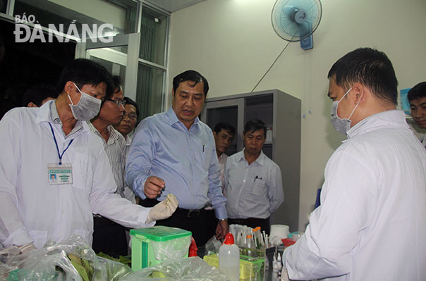 Chủ tịch UBND thành phố Huỳnh Đức Thơ chứng kiến việc lấy mẫu kiểm tra chất tồn dư thuốc bảo vệ thực vật tại chợ Đầu mối Hòa Cường. Ảnh: PHAN CHUNG