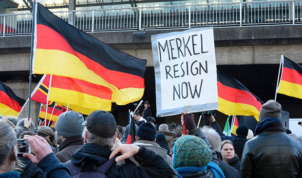 Người biểu tình mang tấm biển “Bà Merkel hãy từ chức ngay” trong dòng người đông đúc ở Berlin ngày 30-7.  Ảnh: Voice of Europe