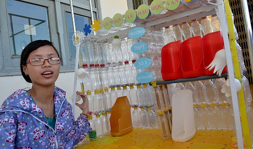 Le Thi Bich Quyen poses for a picture with the floating bookshelf developed by her classmate Le Quang Hoan and herself.