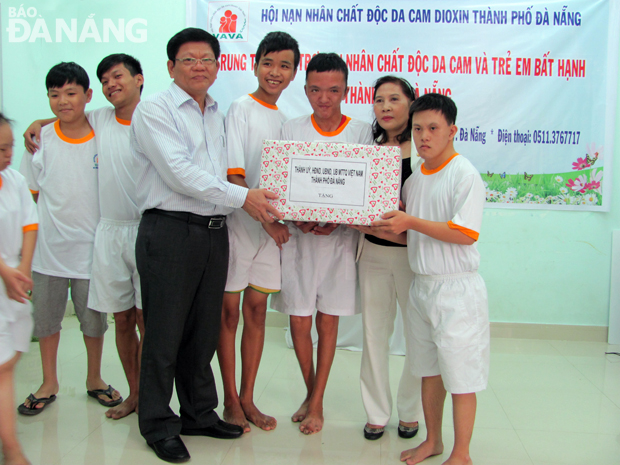 Municipal Party Committee Deputy Secretary Vo Cong Tri presenting gifts to local AO-affected children