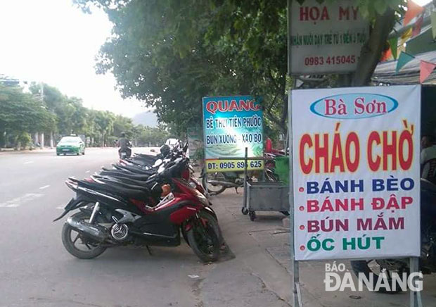 Một điểm kinh doanh chiếm dụng lòng đường Hoàng Văn Thái làm nơi để xe. 				  Ảnh: V.QUANG
