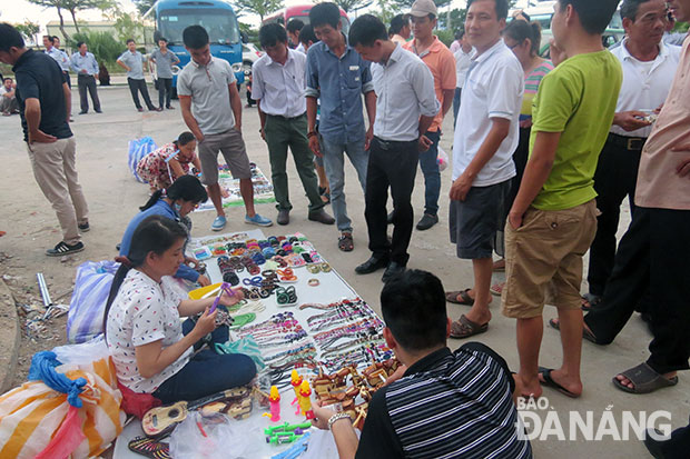 Hàng rong tụ tập trước các nhà hàng đông khách du lịch lui tới. Trong ảnh: Bày bán hàng rong trước nhà hàng C.N khu biệt thự Đảo Xanh. Ảnh: HÀ THU