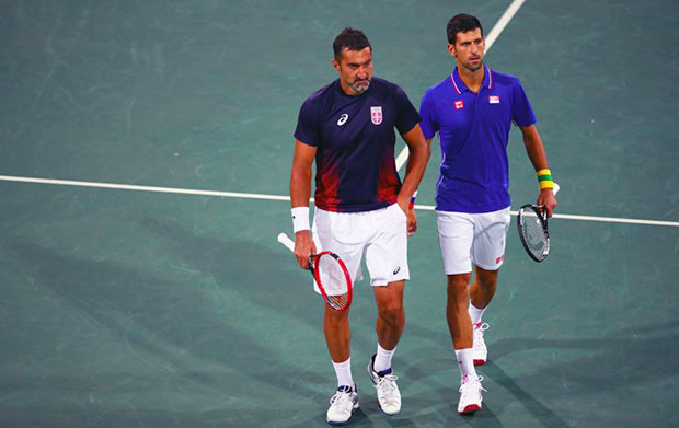 Djokovic (phải) và Zimonjic (trái) rời sân sau thất bại trong trận đánh đôi trước hai tay vợt chủ nhà vào sáng 9-8 vừa qua. Ảnh: CLIVE BRUNSKILL