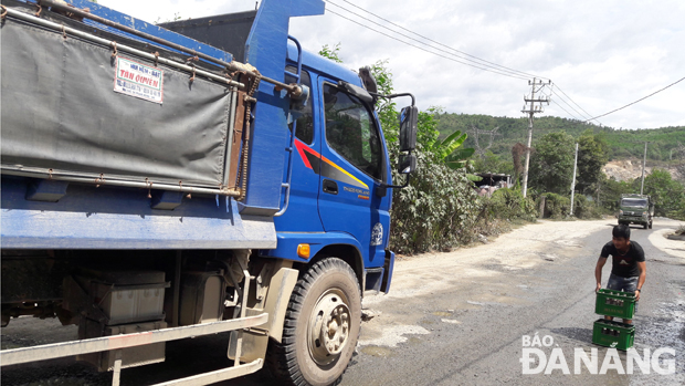 Người dân thôn Phước Thuận dùng vật cản đưa ra đường để hạn chế tốc độ xe ben. Ảnh: NGỌC PHÚ