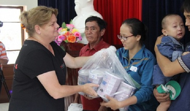 A Lifestart Foundation representative (L) hands over milk to locals in Quang Nam Province, located in central Vietnam, on August 17, 2016. Lifestart Foundation