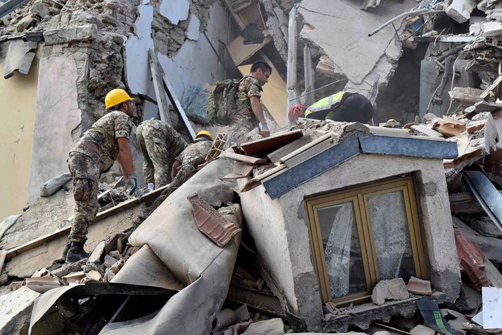 Các nhân viên cứu hộ tại một tòa nhà bị đổ sập ở thị trấn Amatrice, Italy, sau trận động đất 6,2 độ richter xảy ra vào sáng 24/8. Ảnh: Reuters.