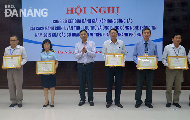 Phó Chủ tịch UBND thành phố Hồ Kỳ Minh trao bằng khen của UBND thành phố cho các đơn vị xếp thứ hạng nhất,nhì, ba về CCHC năm 2015. Ảnh: SƠN TRUNG