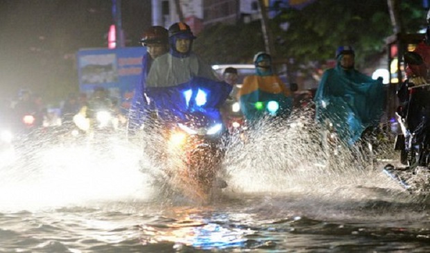 People travel on a street during a heavy rain in Ho Chi Minh City on August 26, 2016. Tuoi Tre