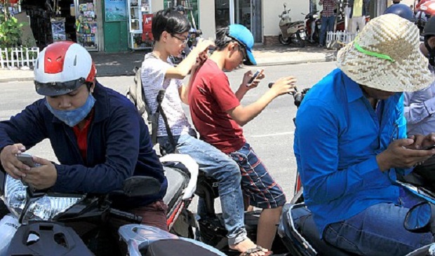 A group of ‘trainers’ in the central Vietnamese city of Da Nang play Pokémon GO while parking on the street. Tuoi Tre