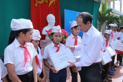 Lãnh đạo Sở GD-ĐT Hà Tĩnh trao tặng sách của NXBGDVN cho các em học sinh (Ảnh: Nhân dân)
