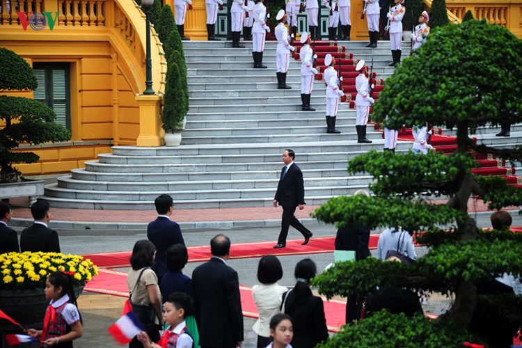 Chủ tịch nước Trần Đại Quang bước ra thảm đỏ chào đón Tổng thống Hollande.