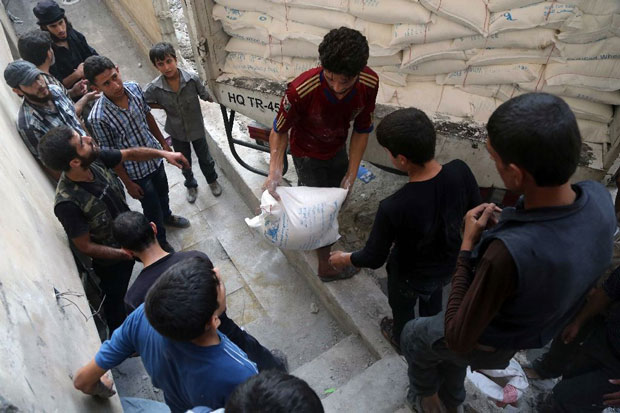 Viện trợ của một tổ chức Trăng lưỡi liềm đỏ được đưa vào khu vực do phiến quân chiếm giữ ở ngoại ô Damascus. 						                                      Ảnh: AFP 