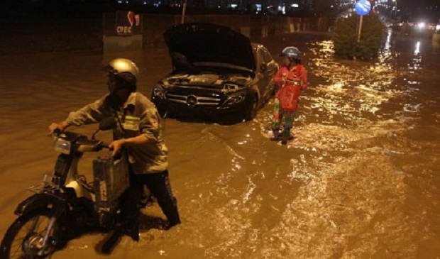 A car and a motorbike break down due to heavy floods following a downpour in Ho Chi Minh City on September 18, 2016. Tuoi Tre