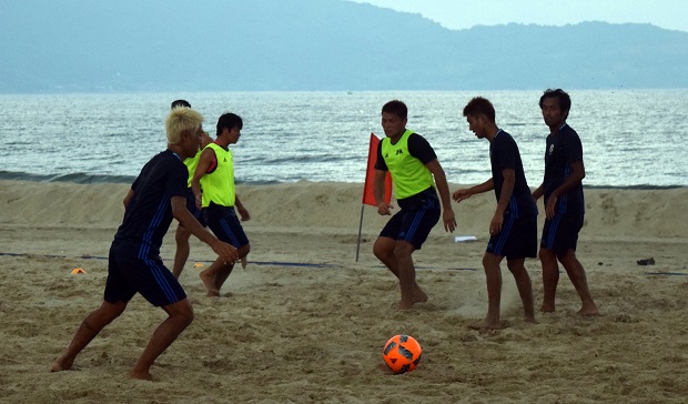    Some football players practising on the beach