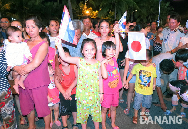 Các khán giả nhí trên tay cầm quốc kỳ của các nước phấn khởi khi được bố mẹ dẫn đi tham gia sự kiện.