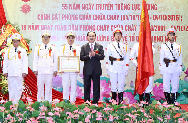 Chủ tịch nước Trần Đại Quang trao Huân chương Bảo vệ Tổ quốc hạng nhất cho Cục Cảnh sát Phòng cháy chữa cháy.  								        Ảnh: TTXVN