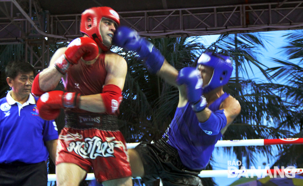 Vietnamese contestant (blue) scores by hitting his opponent's face in the muay Thai competition