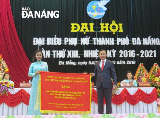 Secretary of the municipal Party Committee Nguyen Xuan Anh (right) presenting the laudatory banner to a representative from the local Women's Union