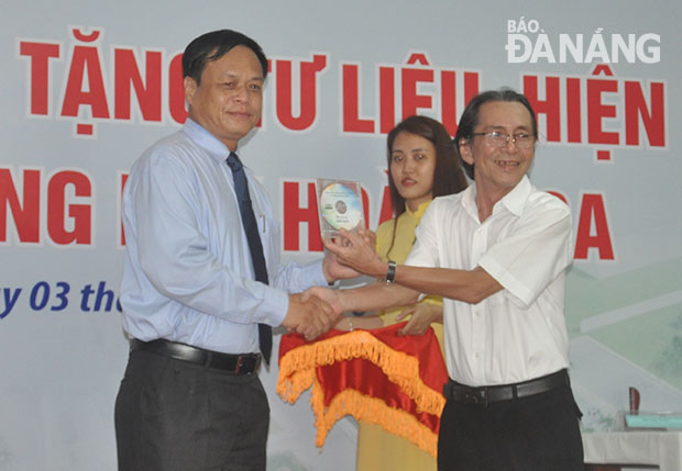 Meritorious artist Trung (left) presenting a copy of his documentary film ‘Nho Dao’ to a representative from the Hoang Sa Islands People’s Committee