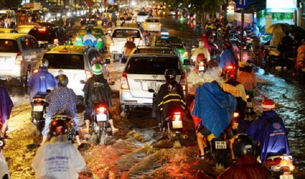 Vehicles struggle in a flooded street in Ho Chi Minh City. Tuoi Tre