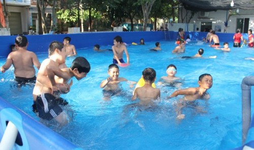 Children play in the water in a cheaply-built pool in Quang Ngai Province