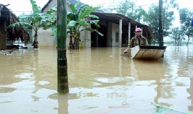 A man paddles a boat near his submerged house during a flood in Vietnam's central Ha Tinh province, October 15, 2016. Reuters