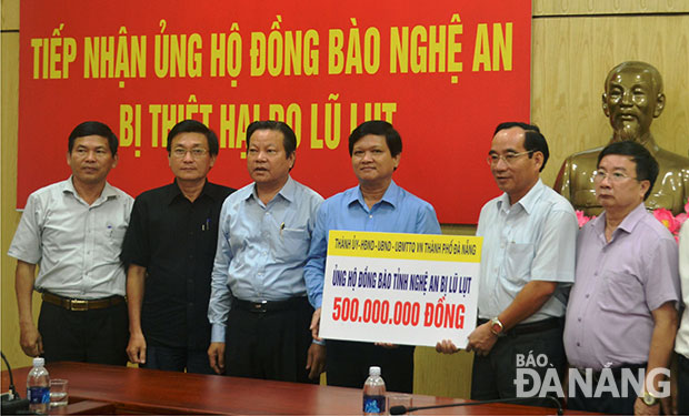 Phó Chủ tịch HĐND thành phố Đà Nẵng Nguyễn Nho Trung trao 500 triệu đồng của Đà Nẵng hỗ trợ đồng bào tỉnh Nghệ An. Ảnh: NGỌC PHÚ