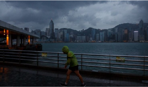 A man jogs along a promenade running along Victoria Harbour as Typhoon Haima approaches Hong Kong early on Oct 21, 2016, shortly after the typhoon signal eight warning was raised. AFP