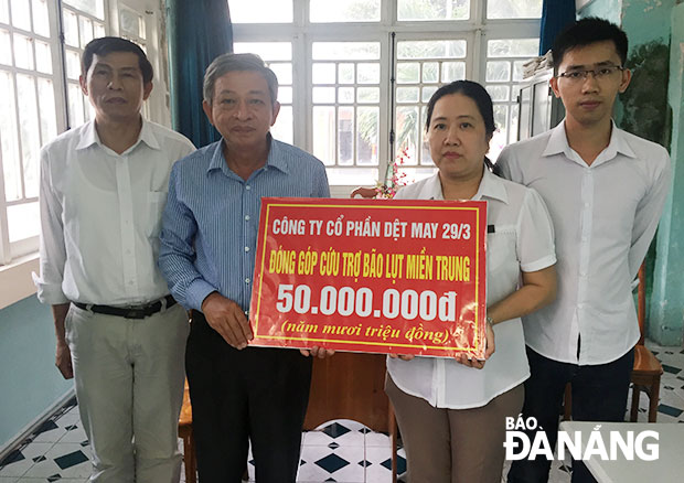 Đại diện Công ty CP Dệt-may 29-3 trao 50 triệu đồng cho ông Lê Quang Á, Phó Tổng Biên tập Báo Đà Nẵng.  		         Ảnh: NGỌC ĐOAN