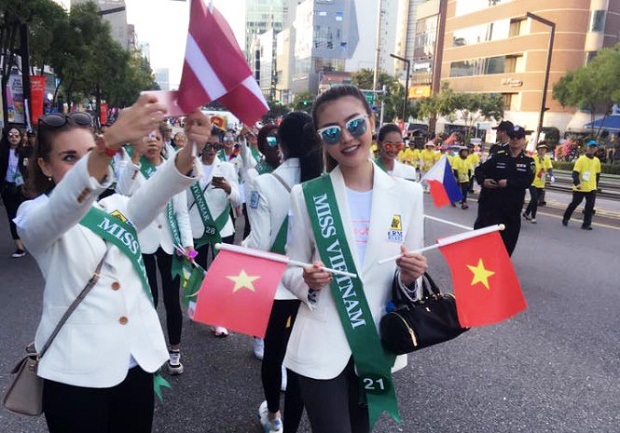 uyen carries the Vietnam flag in a parade on the streets of Seoul during the contest. Photo: Duyen's Facebook page