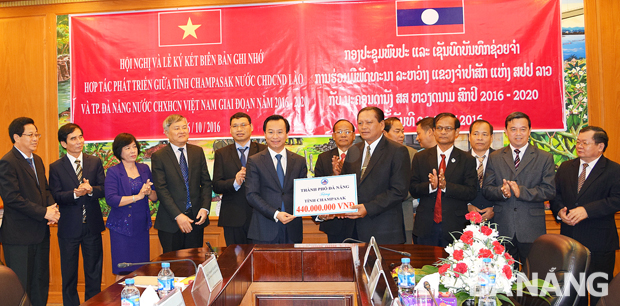 Secretary Anh (left) giving 440 million VND from the city budget to the province to implement some local social welfare activities 