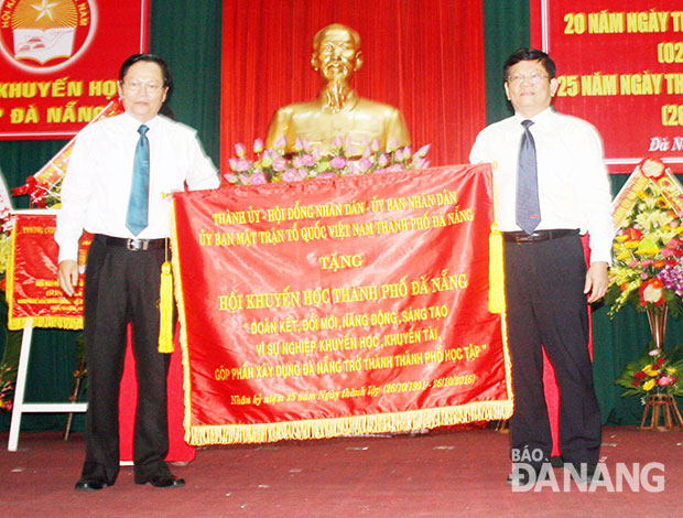  Deputy Secretary Tri (right) presenting the joint laudatory banner to a representative from the municipal Study Encouragement Association