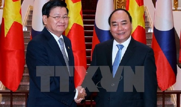 Vietnamese Prime Minister Nguyen Xuan Phuc (R) shakes hands with his Laotian counterpart Thongloun Sisoulith in Hanoi on October 25, 2016. Vietnam News Agency