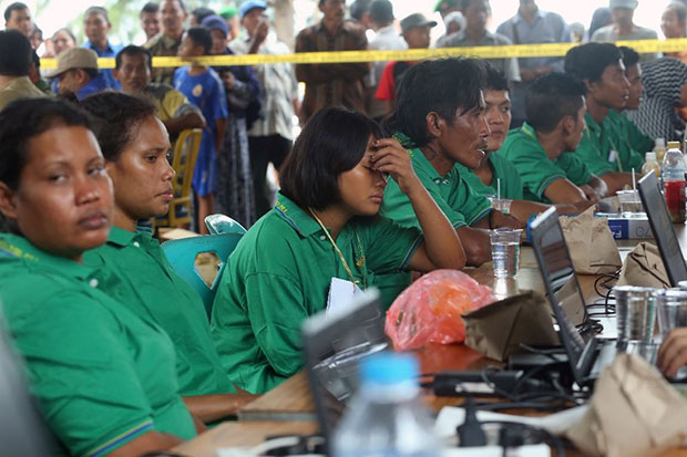 Những người sống sót chờ hoàn tất các thủ tục tại một trạm cảnh sát. 					Ảnh: AFP